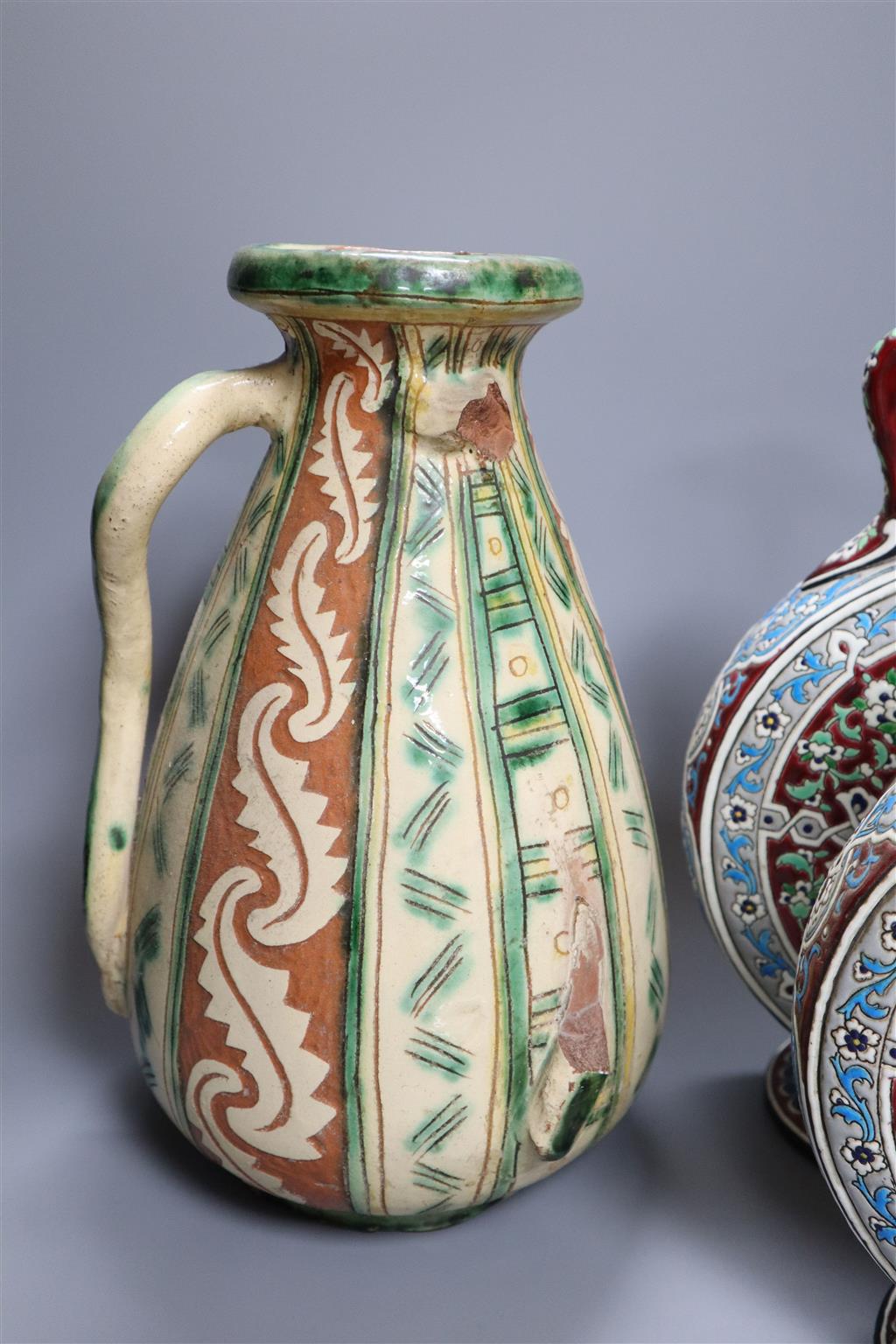 A pair of Isnik inspired pottery moon flasks, 30cm and an Italian pottery vase and another